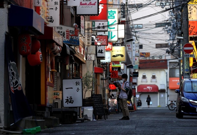 多くの店が新たに休業を決めた夜の繁華街。人影のない街角で兵庫県の見回り活動を行う男性が営業状況などを確認して回っていた＝２５日午後、神戸市中央区中山手通１（撮影・小林良多）