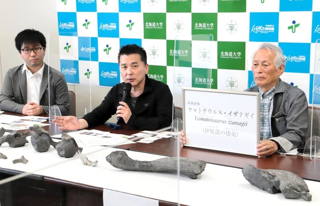洲本市で見つかった新属新種の恐竜について説明する北海道大の小林快次教授（中央）と、学名を見せる発見者の岸本眞五さん（右）＝神戸市中央区下山手通５、兵庫県庁