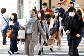少し肌寒さが戻り厚めの上着などに身を包んで歩く人々＝５日午前、神戸市中央区