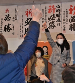 当選を決め支援者らと親指を立てて喜ぶ山崎晴恵氏（右）＝１１日夜、宝塚市小林５（撮影・秋山亮太）