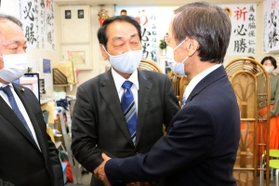 前兵庫県副知事の金沢和夫氏と握手を交わす森脇保仁氏＝１１日夜、宝塚市売布２（撮影・村上貴浩）