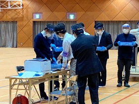 投票数と開票数が合わず、数え直しをする伊丹市職員ら＝１２日午前０時すぎ、伊丹市荒牧４、大阪芸術大学短期大学部
