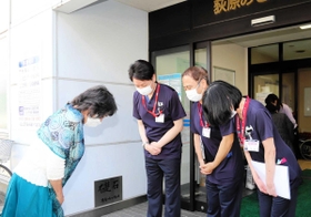 退院時、病院スタッフに頭を下げる女性＝１９日午前、神戸市兵庫区切戸町、荻原みさき病院