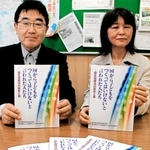 不妊手術を受けさせられた原告らの訴えが詰まった本を持つ支援者＝神戸市中央区橘通１