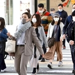 少し肌寒さが戻り厚めの上着などに身を包んで歩く人々＝５日午前、神戸市中央区
