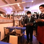 飲食店の感染対策を点検する調査員（左）＝７日午後、神戸市灘区