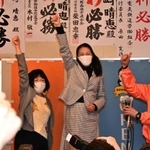 当選を決め支援者らと親指を立てて喜ぶ山崎晴恵氏（中央）＝１１日夜、宝塚市小林５（撮影・秋山亮太）