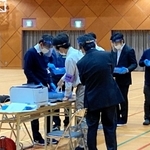 投票数と開票数が合わず、数え直しをする伊丹市職員ら＝１２日午前０時すぎ、伊丹市荒牧４、大阪芸術大学短期大学部