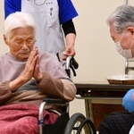 ワクチン接種を受け終わり、医師に手を合わせて感謝する高齢者（左）＝１２日午後０時５分、伊丹市中央４（撮影・秋山亮太）