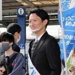 ＪＲ須磨駅前でＰＲのチラシを持って駅前に立つ斎藤元彦氏＝１６日午前、神戸市須磨区