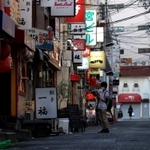 多くの店が新たに休業を決めた夜の繁華街。人影のない街角で兵庫県の見回り活動を行う男性が営業状況などを確認して回っていた＝２５日午後、神戸市中央区中山手通１（撮影・小林良多）