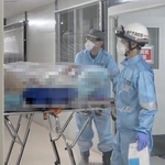 ストレッチャーに患者を乗せて搬送する神戸市消防局の救急隊員ら＝２０２０年１２月、神戸市中央区港島南町２、市立医療センター中央市民病院（画像の一部を加工しています）