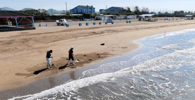 潮干狩りの営業を休止している砂浜を清掃するスタッフ＝３日午前、姫路市的形