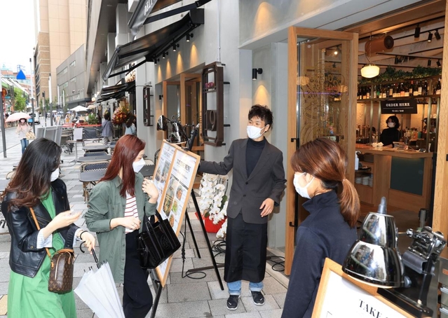 ようやく本格的にオープンし、小雨の中で営業する飲食店の店員たち＝１２日午後、神戸市中央区加納町４（撮影・吉田敦史）