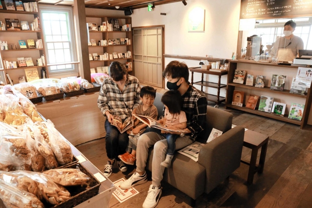 妖怪の本を読んでくつろぐ家族連れ＝福崎町西田原