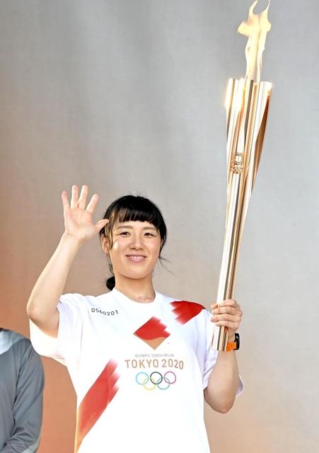 聖火のトーチを持ち手を振る丸山美穂さん＝２３日午後、姫路城三の丸広場（撮影・高部洋祐）