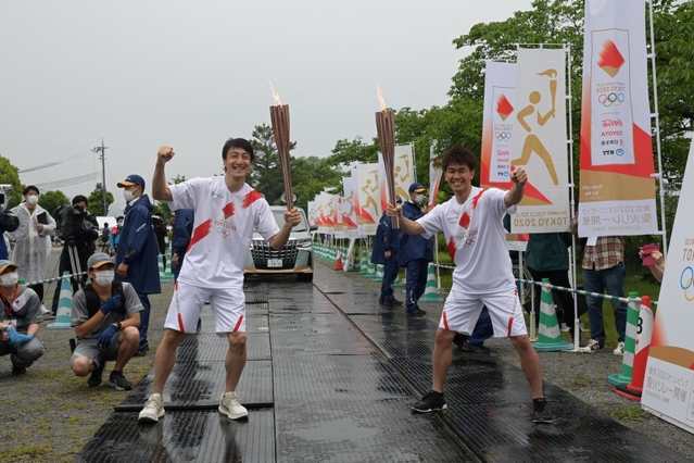 トーチキスをする朝原宣治さん（左）と武井壮さん＝２４日午後、丹波篠山市北新町、篠山城跡三の丸広場