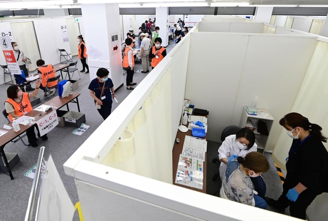 ずらりと並ぶブースでワクチン接種を受ける高齢者ら＝２５日午後、神戸市中央区東川崎町１（撮影・中西幸大）