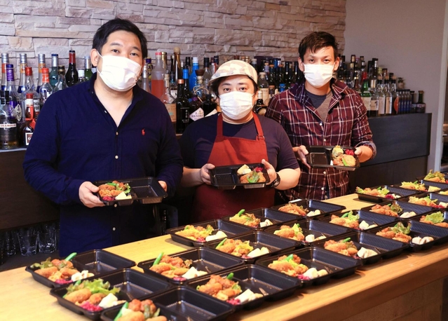 弁当を準備する青木健郎さん（左）ら。友人たちも協力する＝神戸市灘区水道筋６