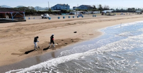 潮干狩りの営業を休止している砂浜を清掃するスタッフ＝３日午前、姫路市的形