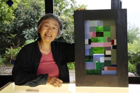 「気に入っている」という１０年ほど前の作品を手にする森本康代さん。額は古民家の壊れた網戸でこしらえている＝神戸市垂水区（撮影・長嶺麻子）