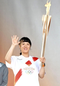 聖火のトーチを持ち手を振る丸山美穂さん＝２３日午後、姫路城三の丸広場（撮影・高部洋祐）
