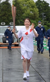 聖火を持ち走る紀平梨花＝２４日午後、丹波篠山市北新町（撮影・秋山亮太）