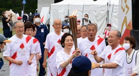 聖火リレー２日目の第一走者を務めた「５６年目のファーストランの会」のメンバー＝２４日午後、丹波篠山市北新町、篠山城跡三の丸広場（撮影・中西幸大）