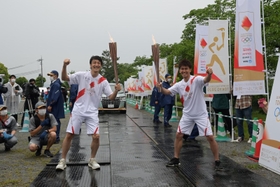 トーチキスをする朝原宣治さん（左）と武井壮さん＝２４日午後、丹波篠山市北新町、篠山城跡三の丸広場