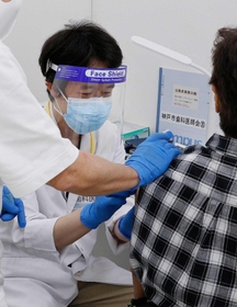 大規模接種会場でワクチンを接種する歯科医＝２５日午後、神戸市中央区東川崎町１