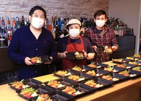弁当を準備する青木健郎さん（左）ら。友人たちも協力する＝神戸市灘区水道筋６