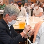 上腕部の模型に模擬注射をする歯科医師＝神戸市中央区橘通４、同市医師会館