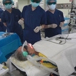 サングラスのような特殊な眼鏡をかけて照射を見守るスタッフ＝４月２３日、神戸市中央区楠町７、神戸大病院（神戸大学・神戸新聞共同撮影）