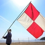 津波発生を想定して旗を振る女性＝たつの市御津町黒崎