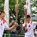 トーチキス後にポーズを決める朝原宣治さん（左）と武井壮さん＝２４日午後、丹波篠山市北新町、篠山城跡三の丸広場（撮影・中西幸大）