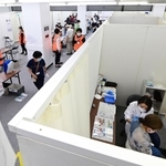 ずらりと並ぶブースでワクチン接種を受ける高齢者ら＝２５日午後、神戸市中央区東川崎町１（撮影・中西幸大）