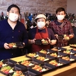 弁当を準備する青木健郎さん（左）ら。友人たちも協力する＝神戸市灘区水道筋６