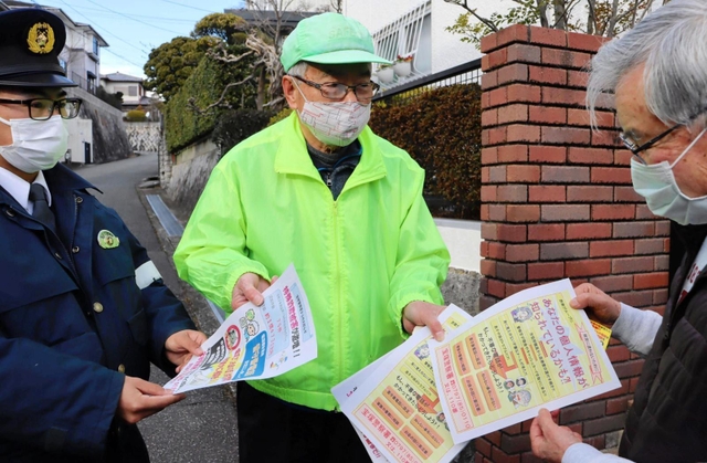 特殊詐欺被害防止を目指し、地域住民にチラシを配る宝塚署員ら＝宝塚市内