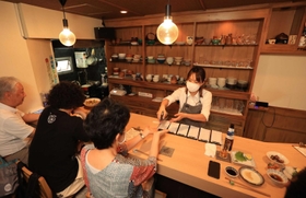 客に手指の消毒を求める店主。酒類を提供しない時短営業を始めた＝１日午後、神戸市中央区中山手通１