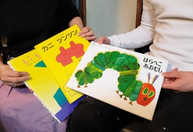 父親から体罰を受けた女性（左）。「自分は手を上げないよう子どもに寄り添った」。長男（右）と読み聞かせの思い出を振り返る＝神戸市内