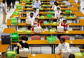 票を数え直す市職員ら＝７日午前０時５６分、尼崎市西長洲町１、ベイコム総合体育館