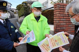 特殊詐欺被害防止を目指し、地域住民にチラシを配る宝塚署員ら＝宝塚市内
