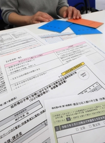 申請書を前にする女性。「給付金はありがたいが、死別ひとり親が差別されている気がする」と話す＝神戸市中央区東川崎町１