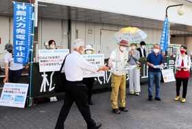 神戸製鋼所の株主総会の会場付近で石炭火力発電所の中止を訴える市民ら＝神戸市中央区港島中町６