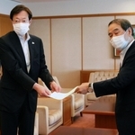 家次恒・日本商工連盟神戸地区代表から立候補要請書を受け取った久元喜造神戸市長（左）＝神戸市役所