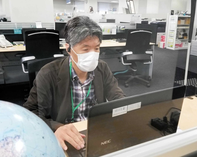 勤務する岡田太丞さん。視覚障害を音声パソコンで補う＝大阪市内（本人提供）