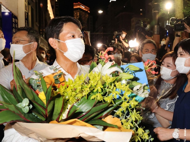 事務所で喜びの言葉を述べた後、入りきれなかった支援者から祝福される斎藤元彦氏（左）＝１８日午後８時２９分、神戸市中央区布引町３（撮影・吉田敦史）