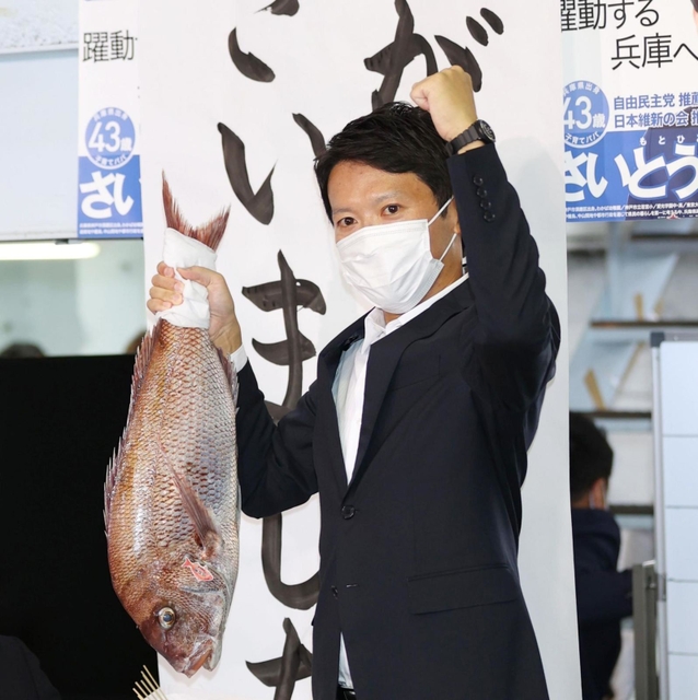 支持者から贈られた鯛を掲げる斎藤元彦氏＝１８日午後８時１２分、神戸市中央区布引町３（撮影・小林良多）