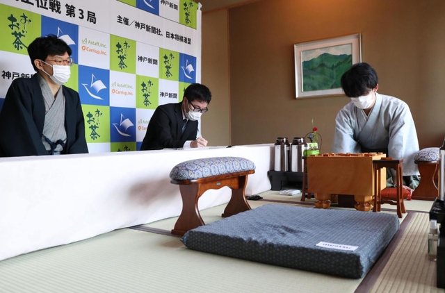 豊島将之竜王より先に昼食休憩を終え、将棋盤の前で熟考する藤井聡太王位（右）。左端は立会人の谷川浩司九段＝２２日午後１時２６分、神戸市北区有馬町の「中の坊瑞苑」（撮影・辰巳直之）