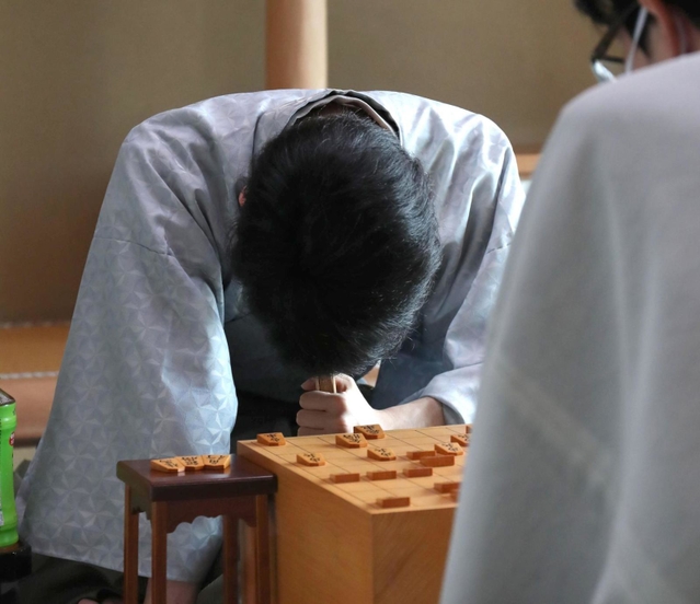 対局中、熟考する藤井聡太王位。右は豊島将之竜王＝２２日午後１時３２分、神戸市北区有馬町の「中の坊瑞苑」